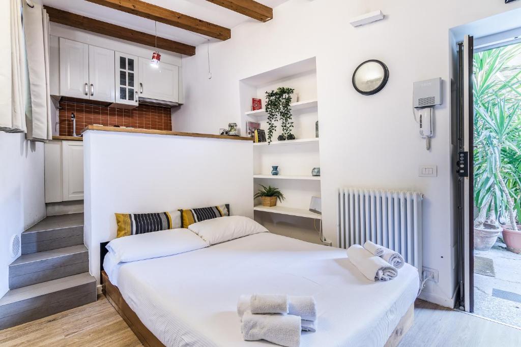 ミラノにあるSecret Navigli Suiteの小さなベッドルーム(白いベッド1台、階段付)