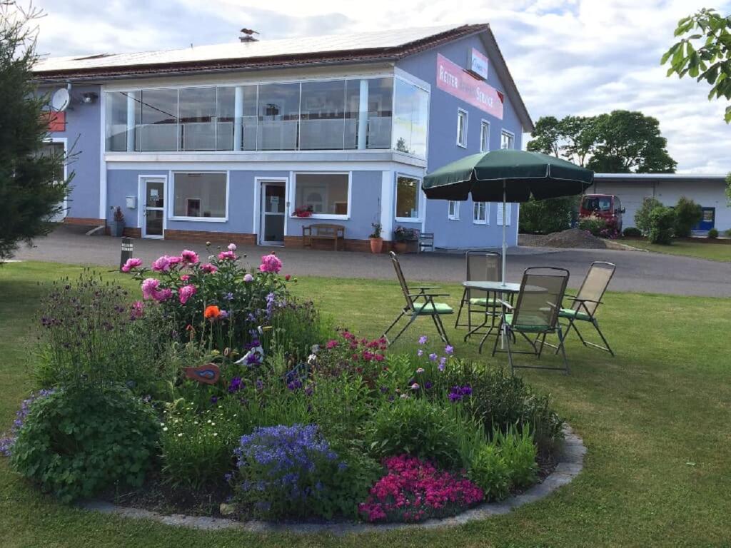 a blue house with a table and chairs and flowers at Monis Ferienwohnung in Tännesberg