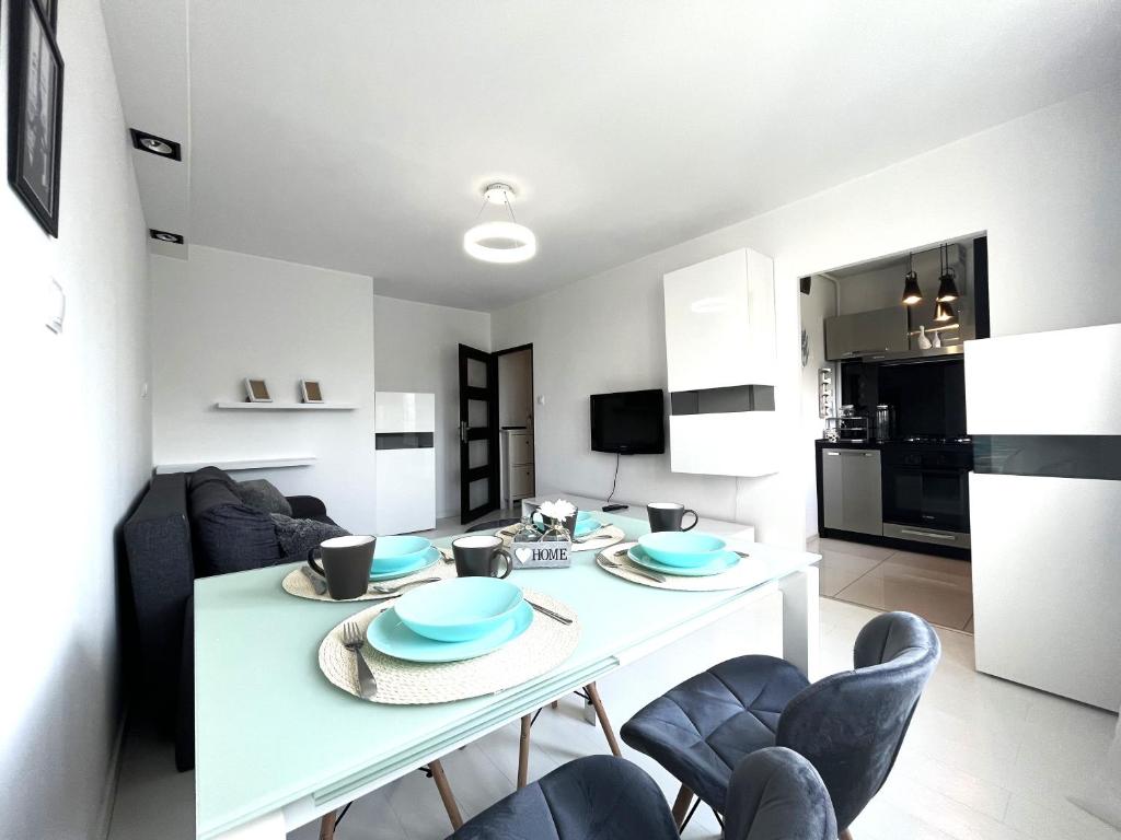 uma cozinha e sala de estar com uma mesa branca e cadeiras em INFLANCKA Apartment - Self Check-In 20h em Breslávia