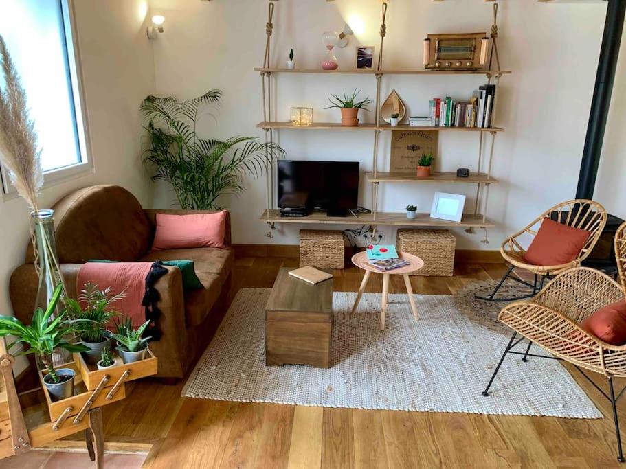 a living room with a couch and a table at La petite maison de Justin - Jacuzzi privatif in Bagnères-de-Bigorre