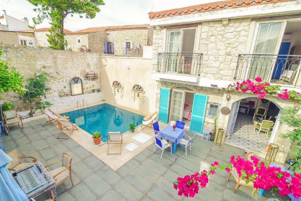 un patio con piscina y una casa en Alacati Asmali Konak Hotel, en Alacati