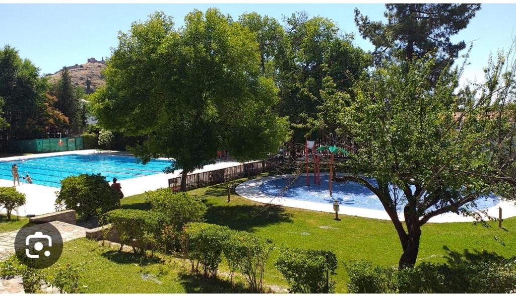 uma vista sobre uma grande piscina com um parque infantil em Apartamento La alberca 1 em Aracena