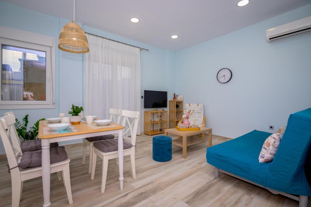 a living room with a table and a blue couch at Zoe's City Apartment in Alexandroupoli