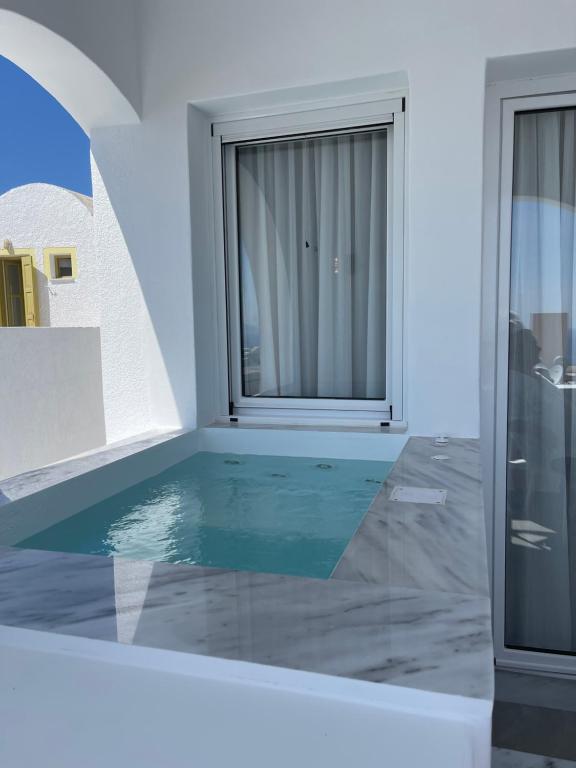 a swimming pool in a room with a window at Galatia Villas in Fira