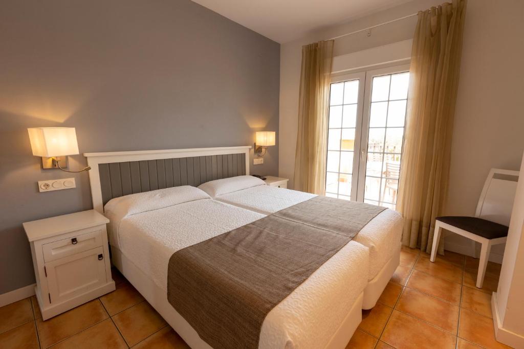 Un dormitorio con una cama grande y una ventana en Dunas de Doñana Resort, en Matalascañas