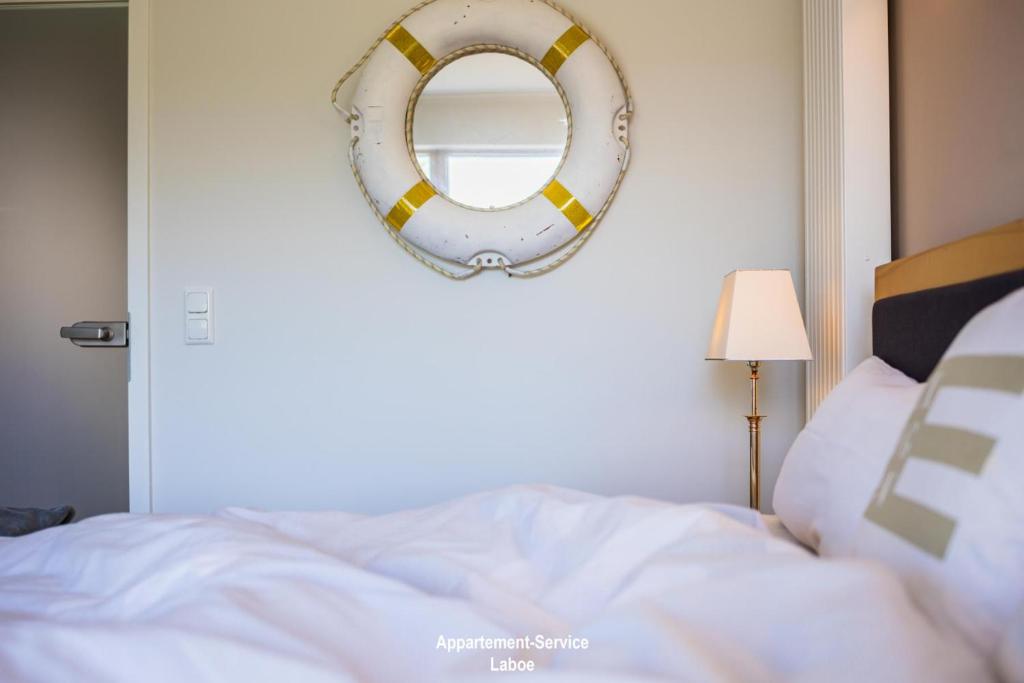 een slaapkamer met een bed en een spiegel aan de muur bij BeachHouse in Laboe