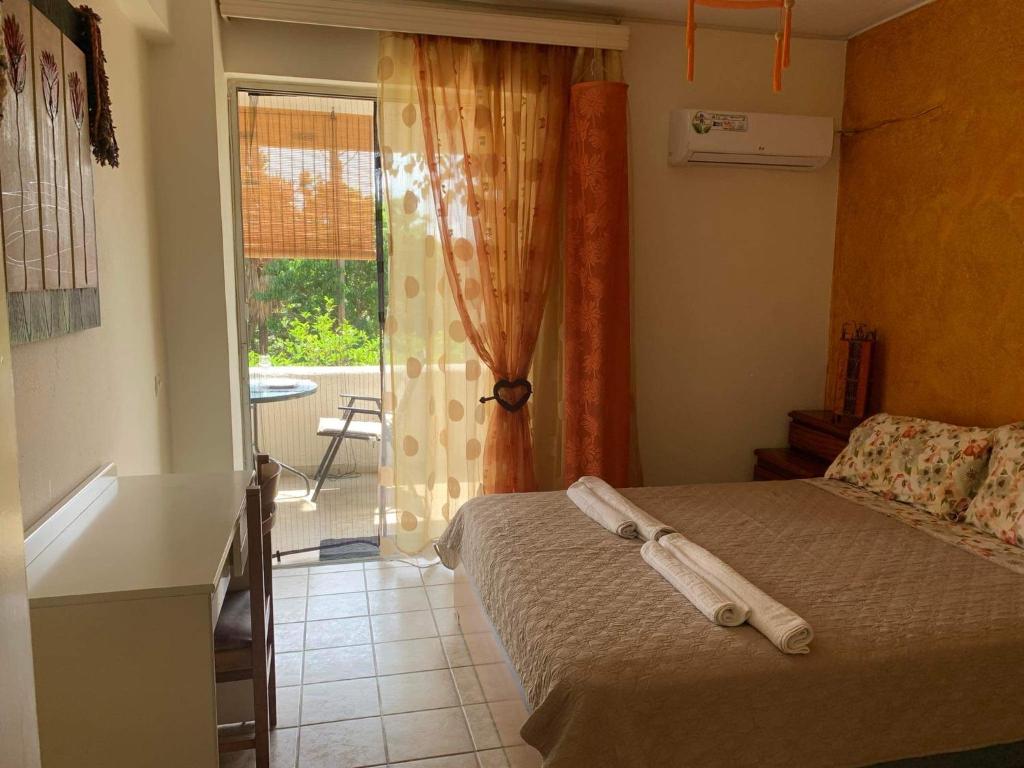 a bedroom with a bed and a window with a patio at Corfu town Kanoni apartment in Corfu