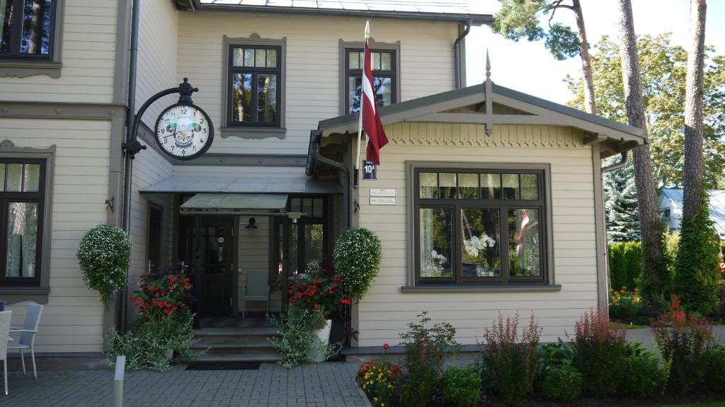 a house with a clock on the front of it at Apartments Livia in Jūrmala