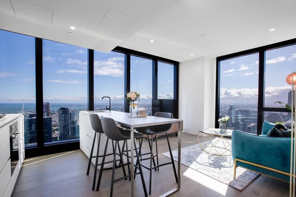 een keuken met een tafel en stoelen en grote ramen bij Stunning City Views 2 bed 2 bath- Ur Urban Oasis！ in Melbourne
