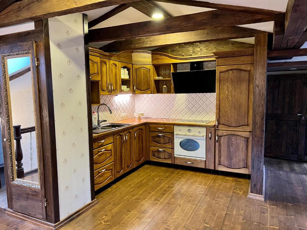 a kitchen with wooden cabinets and a white appliance at Unique apartments in Klaipėda