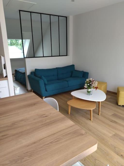 un salon avec un canapé bleu et une table dans l'établissement Agréable studio a la campagne et proche de la mer, à Anctoville-sur-Bosc