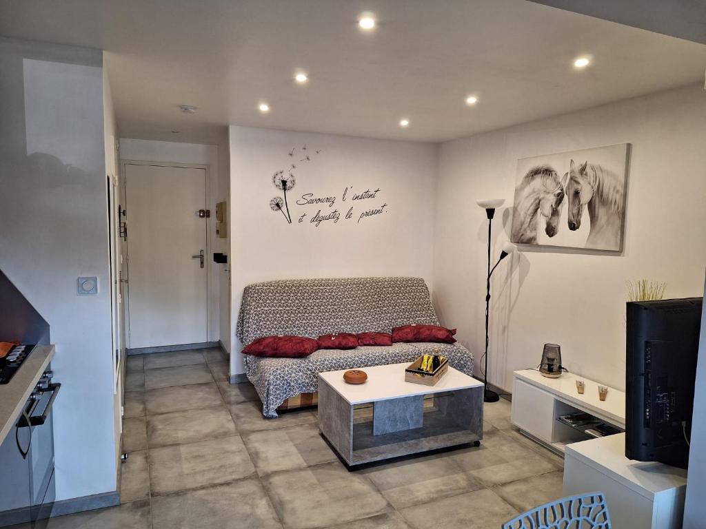 ein Wohnzimmer mit einem Bett und einem Tisch in der Unterkunft au cœur des pins in Cap d'Agde