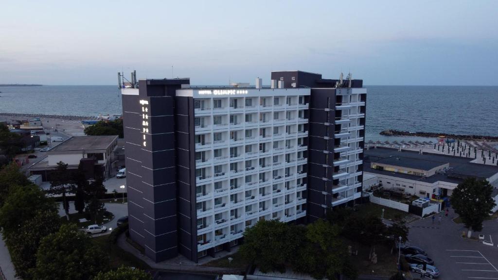 un grand bâtiment noir à côté de l'océan dans l'établissement Hotel Olimpic, à Jupiter