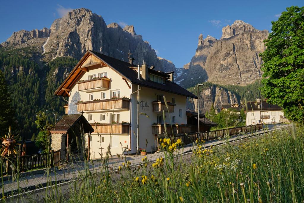 una casa en las vías con montañas en el fondo en Piz Alpin B&B, en Colfosco