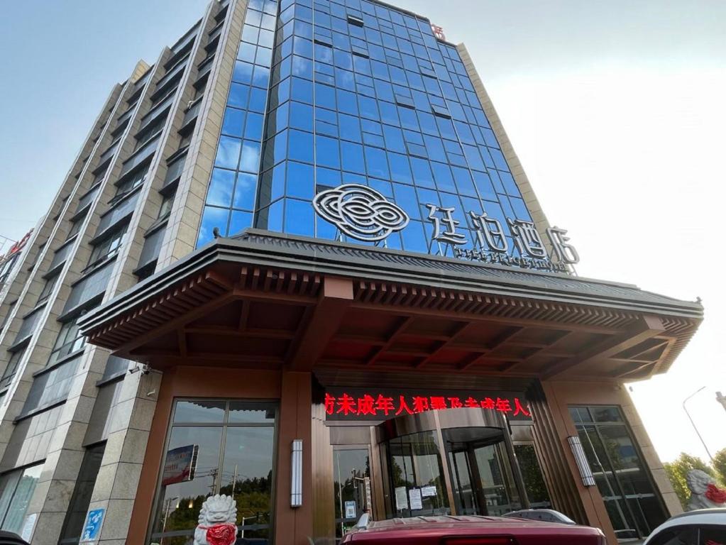 wysoki budynek z znakiem przed nim w obiekcie Till Bright Hotel, Shaoyang Longhui w mieście Longhui