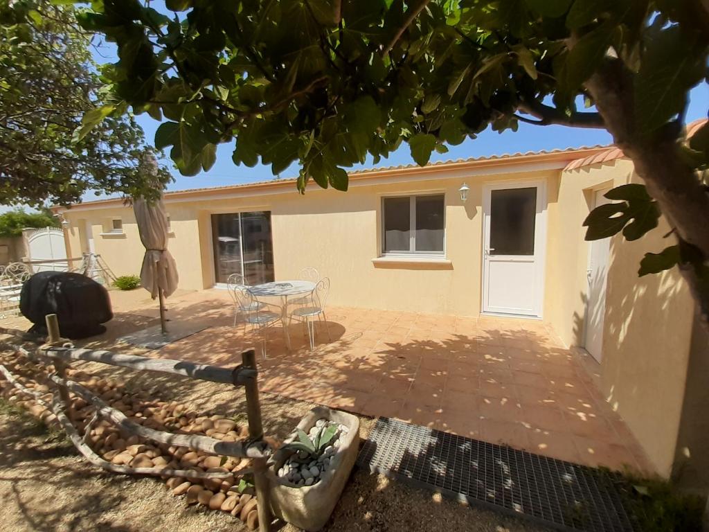 Cette maison dispose d'une terrasse et d'une table. dans l'établissement petite maison de campagne gardoise, à Théziers