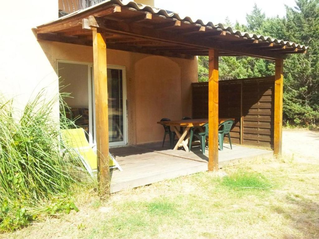 pérgola de madera con una mesa en la cubierta en Cigale 2, en Argelès-sur-Mer