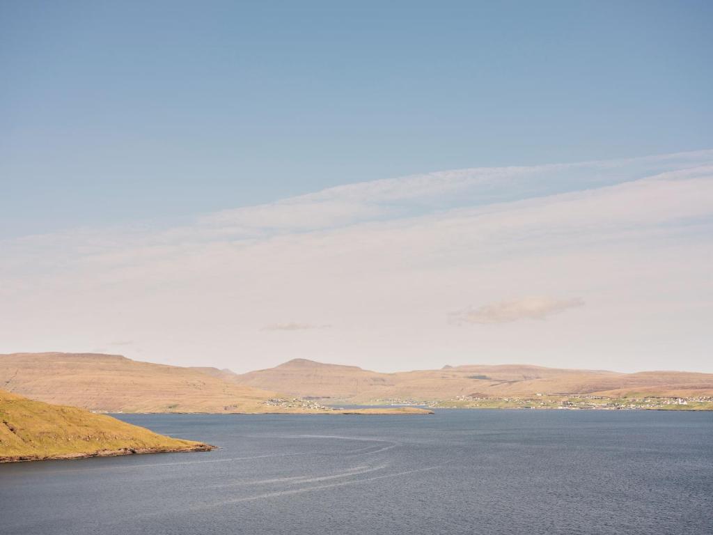 a large body of water with mountains in the background at Studio Apartment / Unique Location / Stunning View in Tórshavn