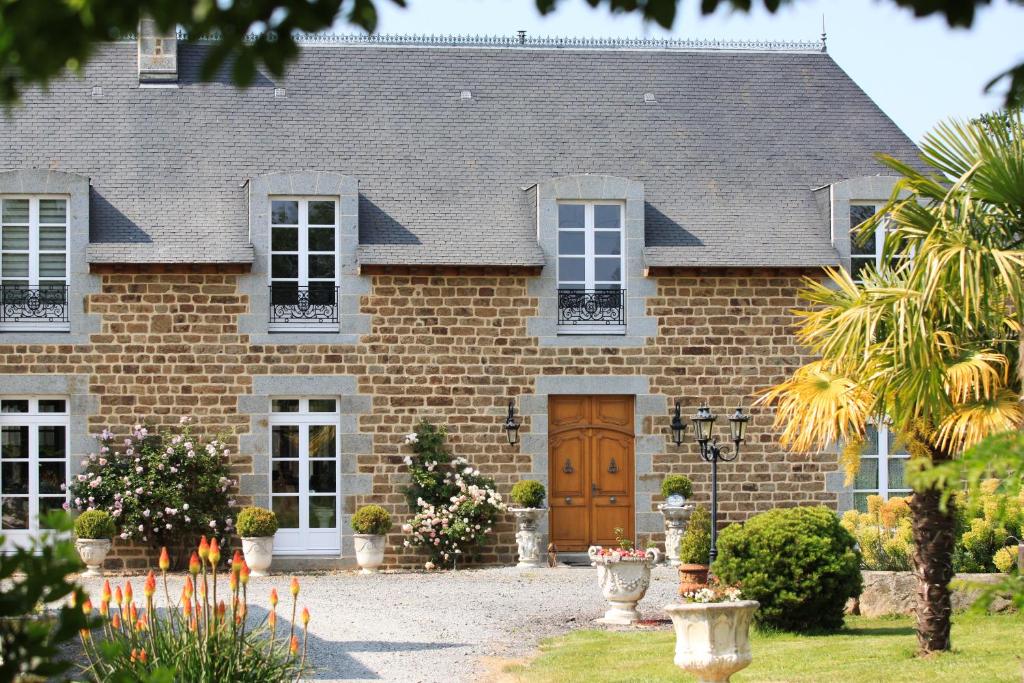 a brick house with a brown door at chez céline in Sens-de-Bretagne