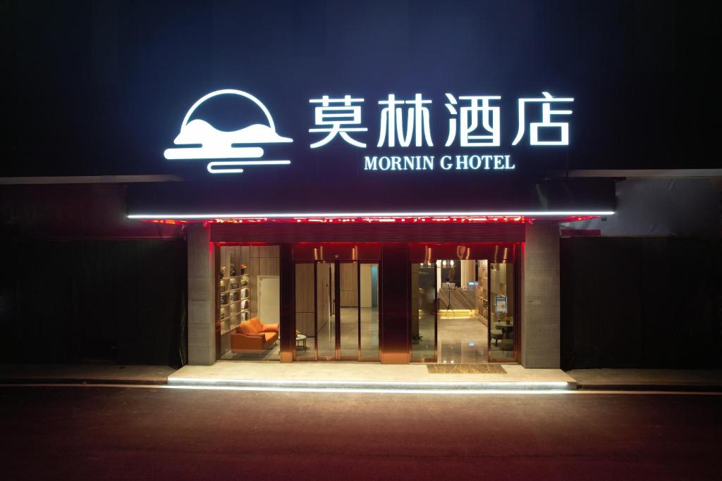 懐化市にあるMorning Hotel, Hecheng District Government Huaihua Collegeの前面にネオンの看板が立つ店