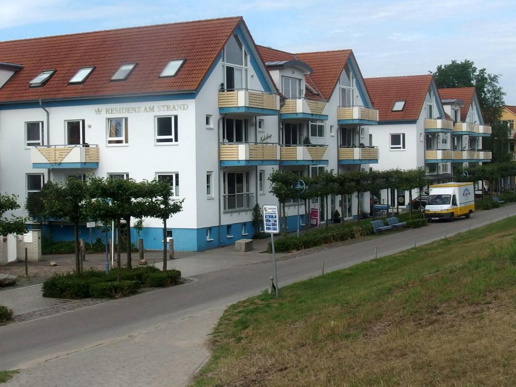 a row of houses on a street with a van at Fewo65 Residenz am Strand in Zingst