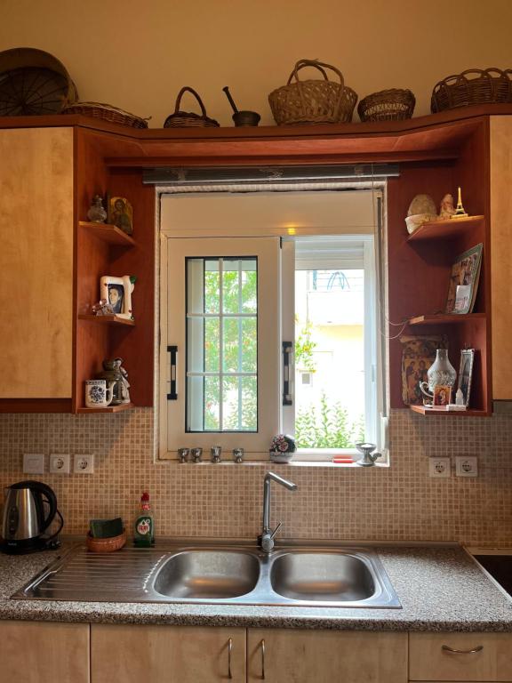 una cucina con lavandino e finestra di Traditional home in Mauromati a Mavrommátion