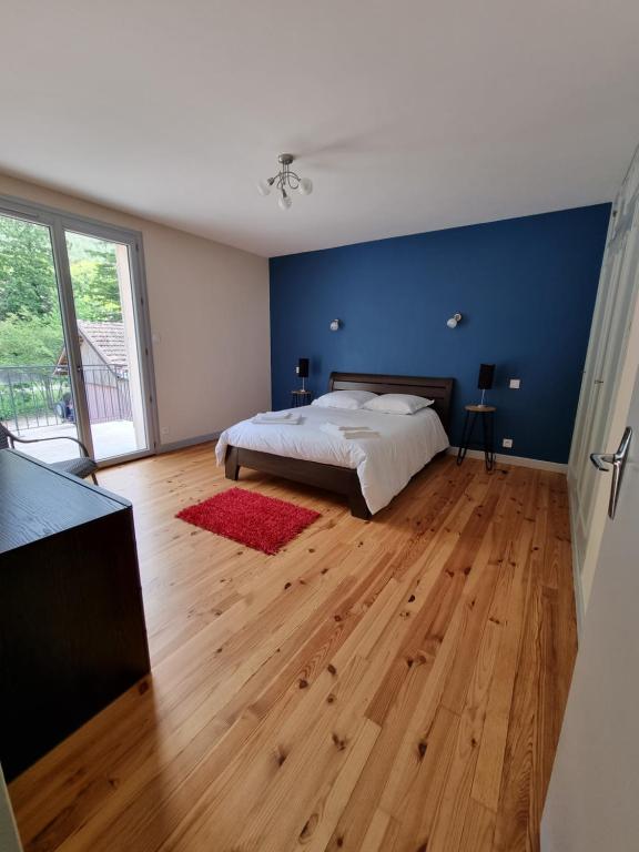 a bedroom with a bed and a blue wall at APPARTEMENT T3 BEAU RIVAGE in Nantua