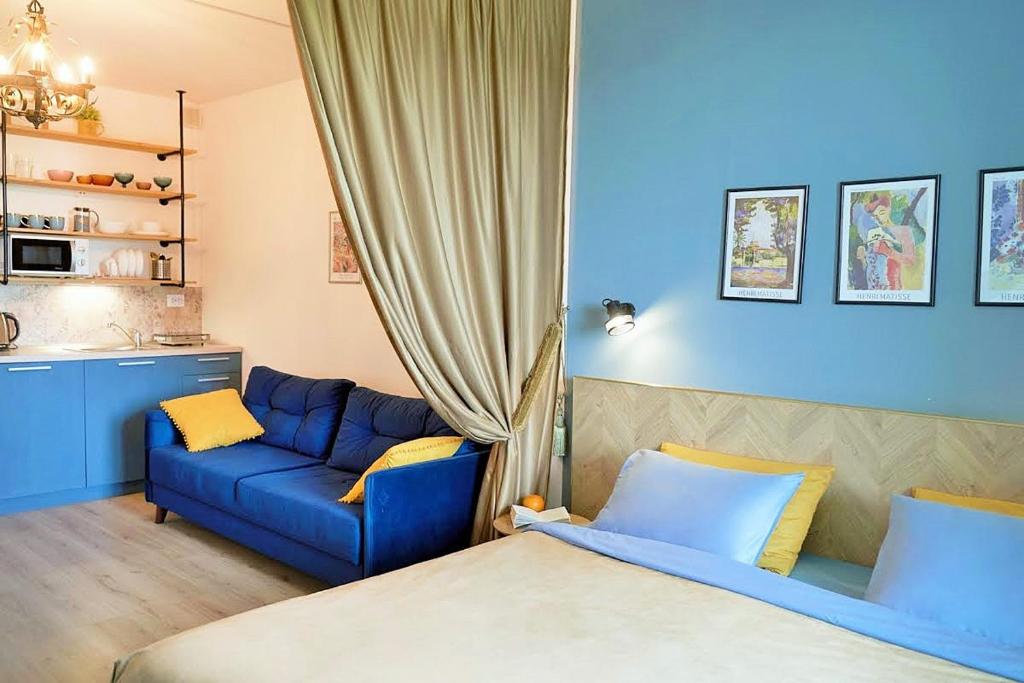a bedroom with a blue couch and a blue sofa at Design Studio in Atlantis Resort&SPA, Burgas Airport in Burgas City