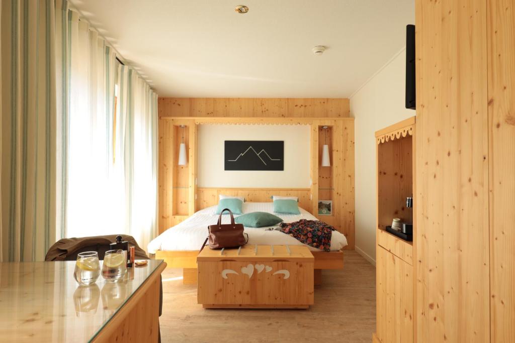 a bedroom with a bed and a large window at LE CLOS DES SOURCES Hôtel & Spa in Thannenkirch