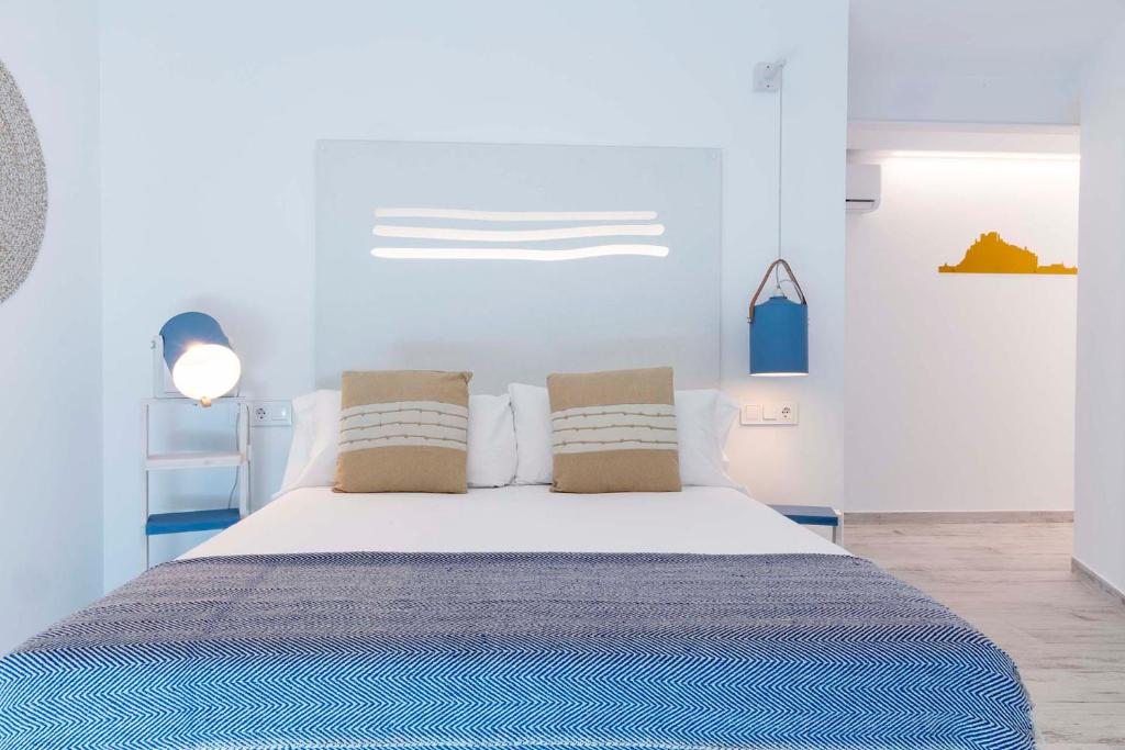 um quarto com uma grande cama branca e 2 almofadas em Hostal Boutique La Mar Serena em Peníscola