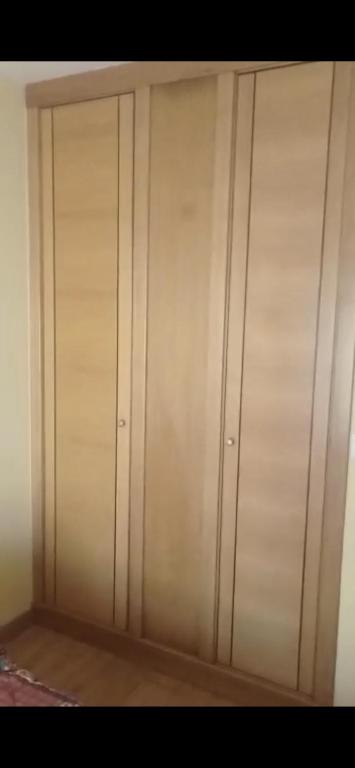 un conjunto de 4 armarios de madera en una habitación en Catoira apto vacacional, en Catoira