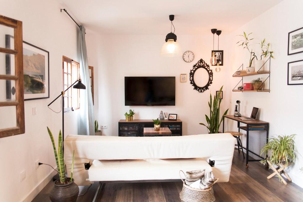 un salon avec un canapé blanc et une télévision dans l'établissement Acogedor apartamento en San Andrés - Casa La Traiña, à San Andrés