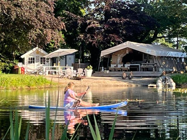 a woman on a paddle board in the water at Het Blauwe Huysch in Putten