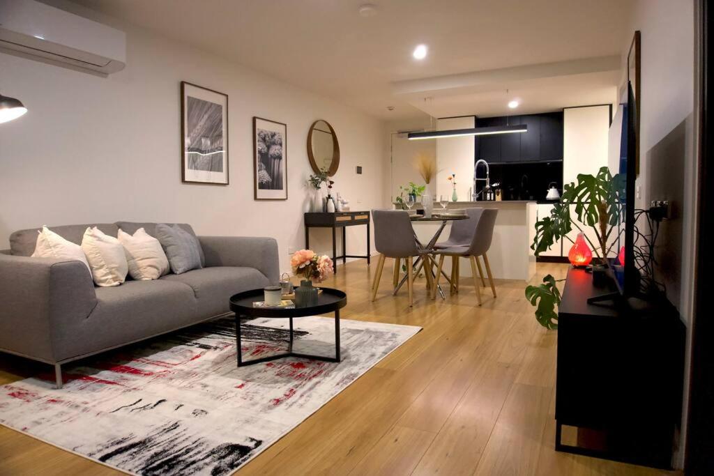 uma sala de estar com um sofá e uma mesa em Stylish Lux Modern 2B2B Apt at Dickson heart em Camberra