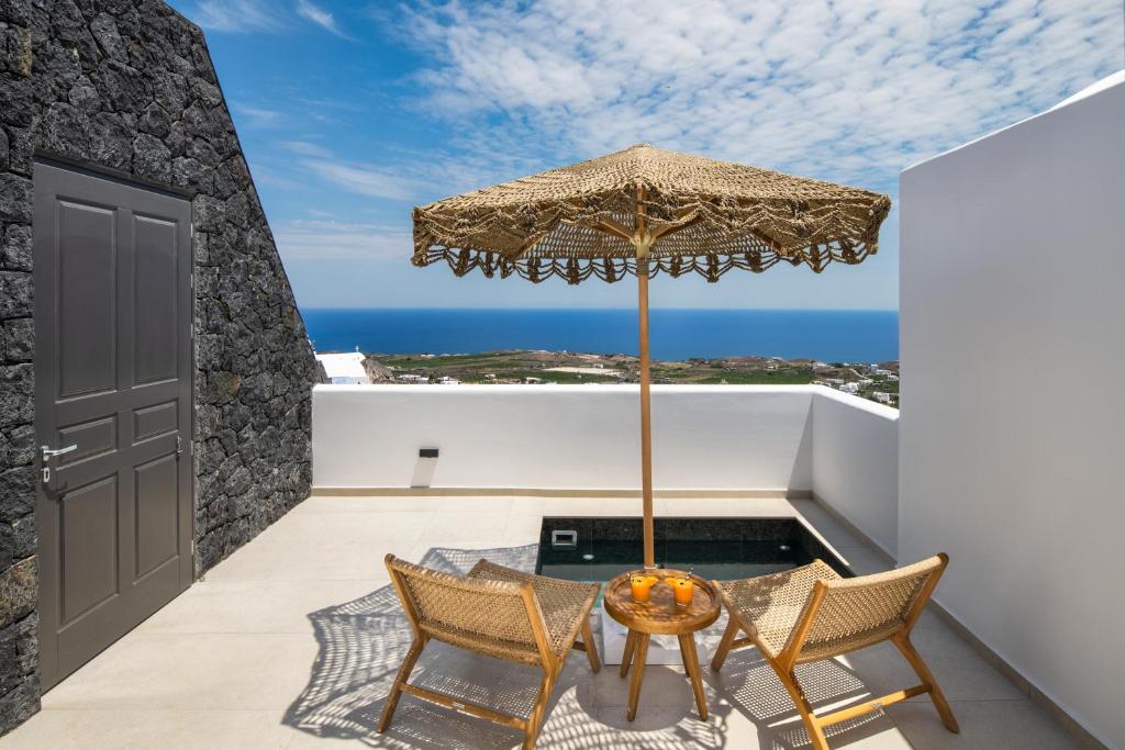 un patio con tavolo, sedie e un ombrellone di Venus Sunrise Suites & Villas a Vourvoúlos