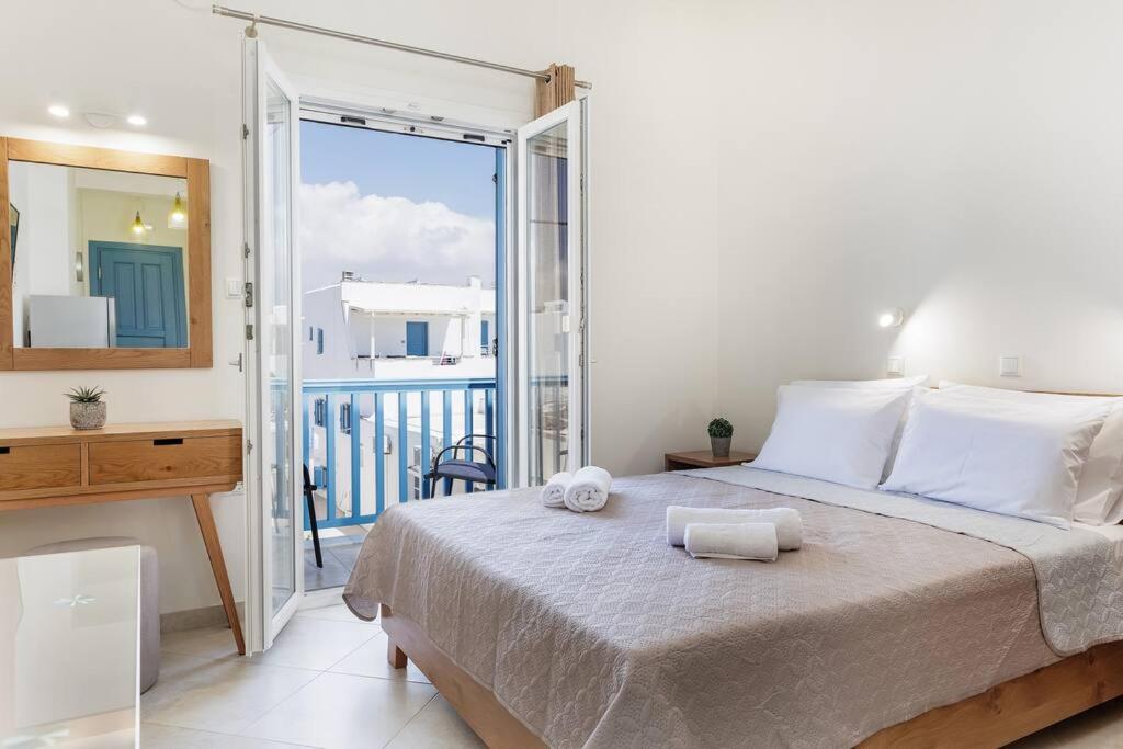 a bedroom with a large bed and a balcony at Naxian Place 2 in Agios Prokopios