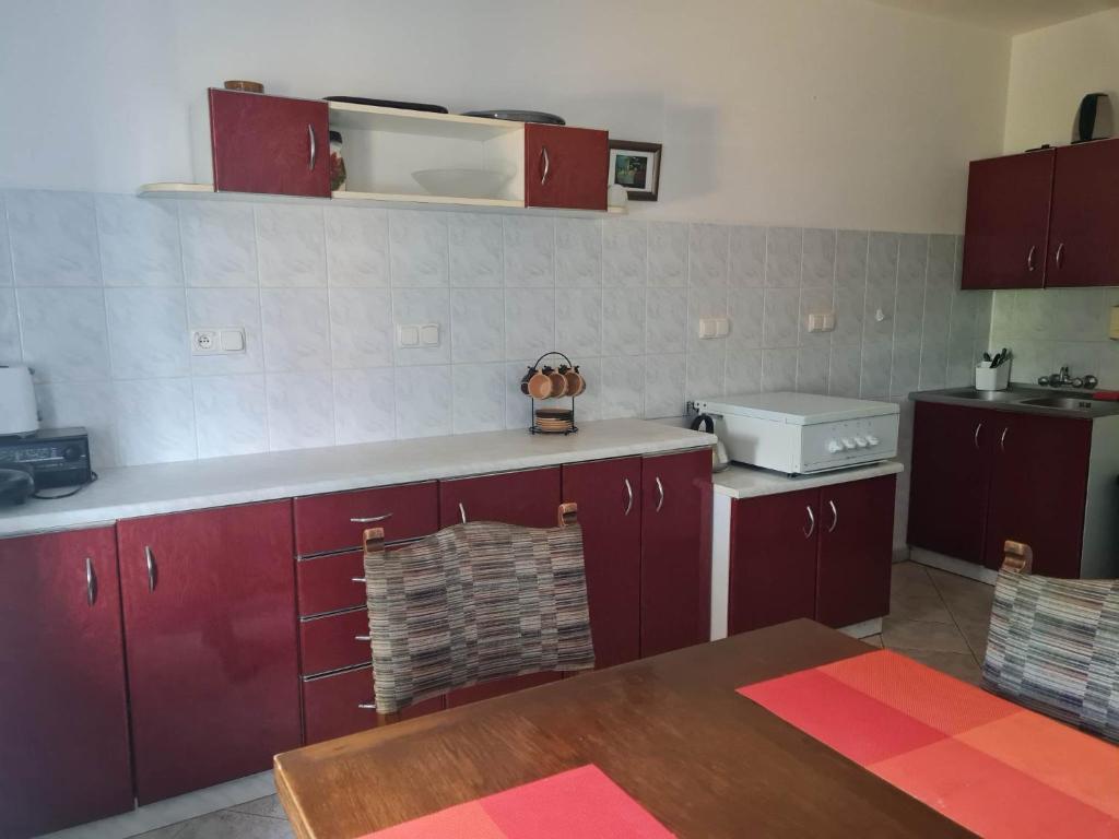 a kitchen with red cabinets and a counter top at Pokoje Gościnne LENAILI in Jarosławiec