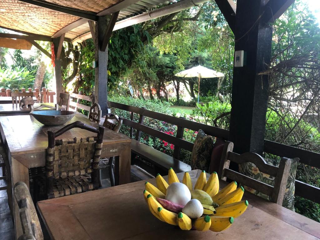 a bowl of fruit sitting on a wooden table at Fazenda Quinta da Esperança- Pousada e Lazer in Tiradentes