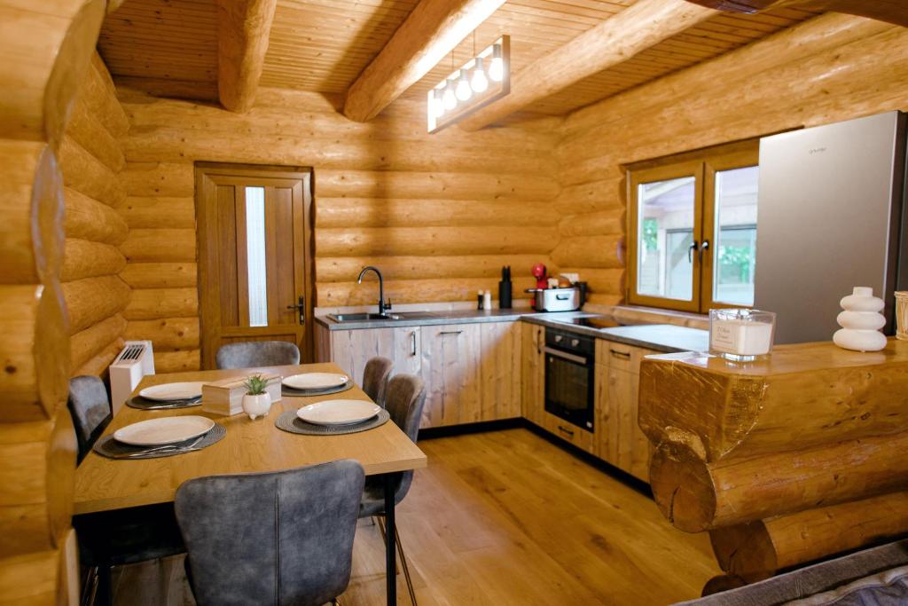 a kitchen with a table and chairs in a log cabin at Das Holzhaus in Sadu