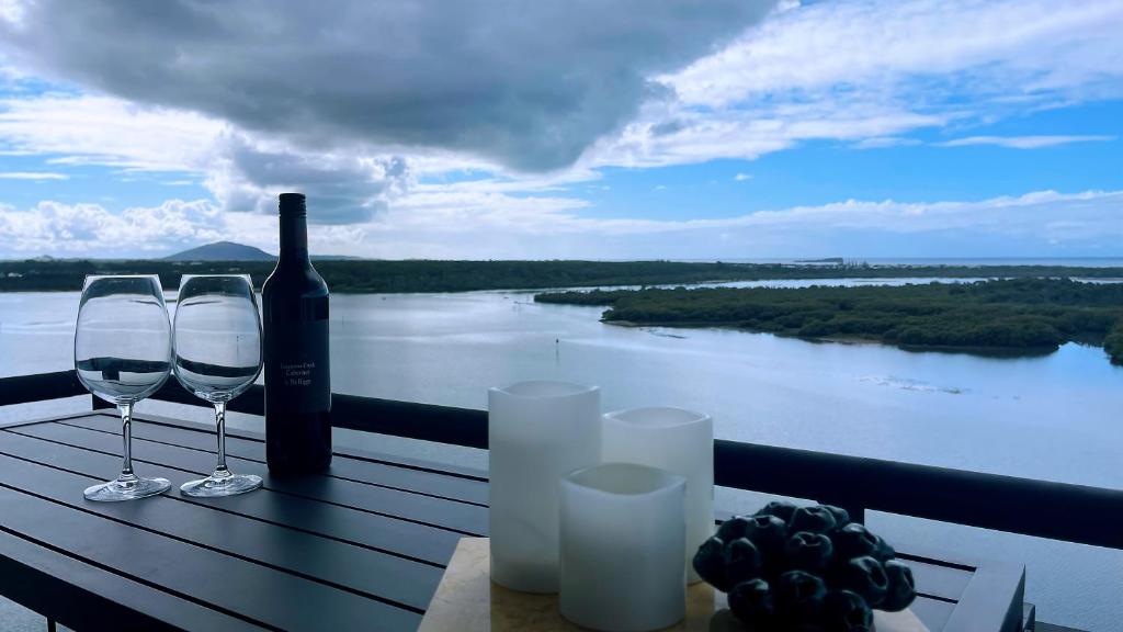 a bottle of wine and two wine glasses on a table at Banyandah Towers in Maroochydore