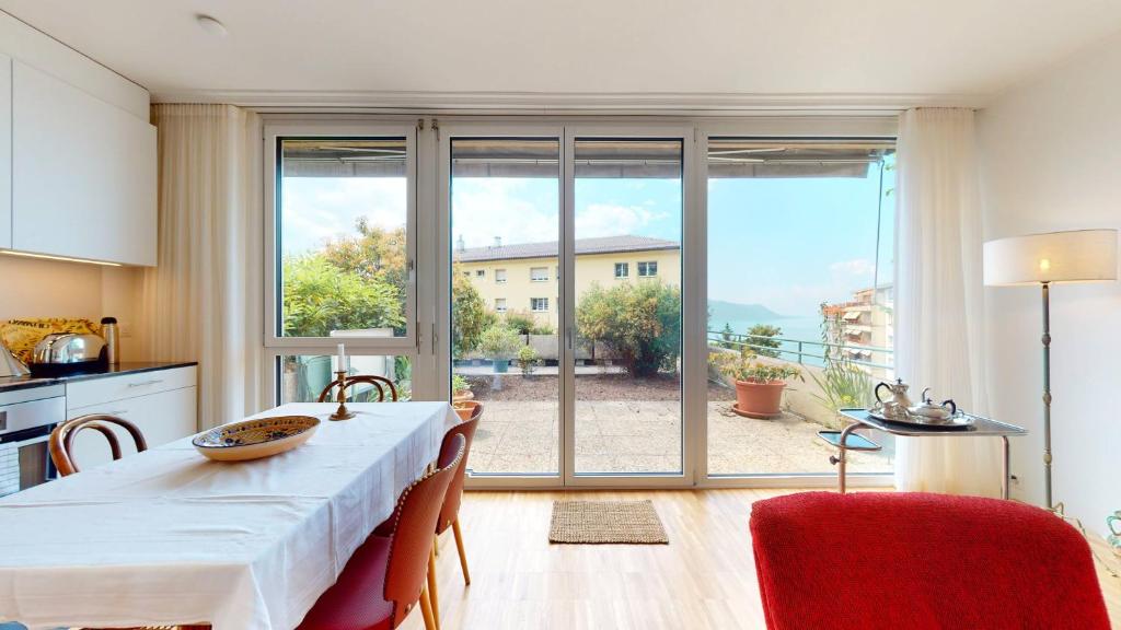 een keuken met een tafel met stoelen en een groot raam bij Bright flat overlooking Lake Geneva in Montreux