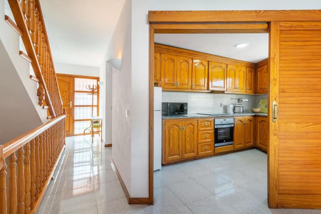 a kitchen with wooden cabinets and a stove at Seamount, a beautiful house overlooking Tamariu in Tamariu