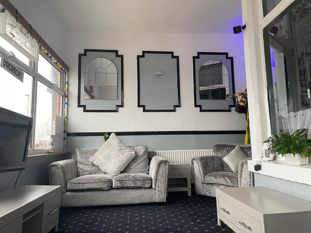 a living room with a couch and two chairs and mirrors at St Albans Hotel in Blackpool