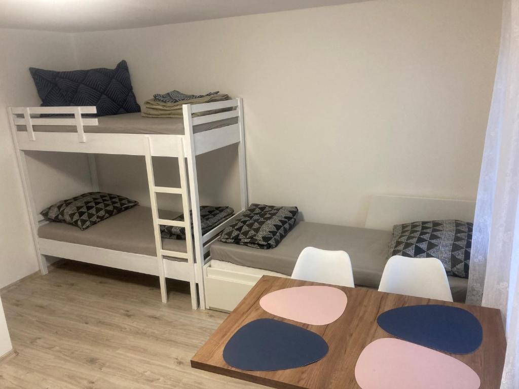 a small room with two bunk beds and a table at Chatka Maya Máchovo jezero in Doksy