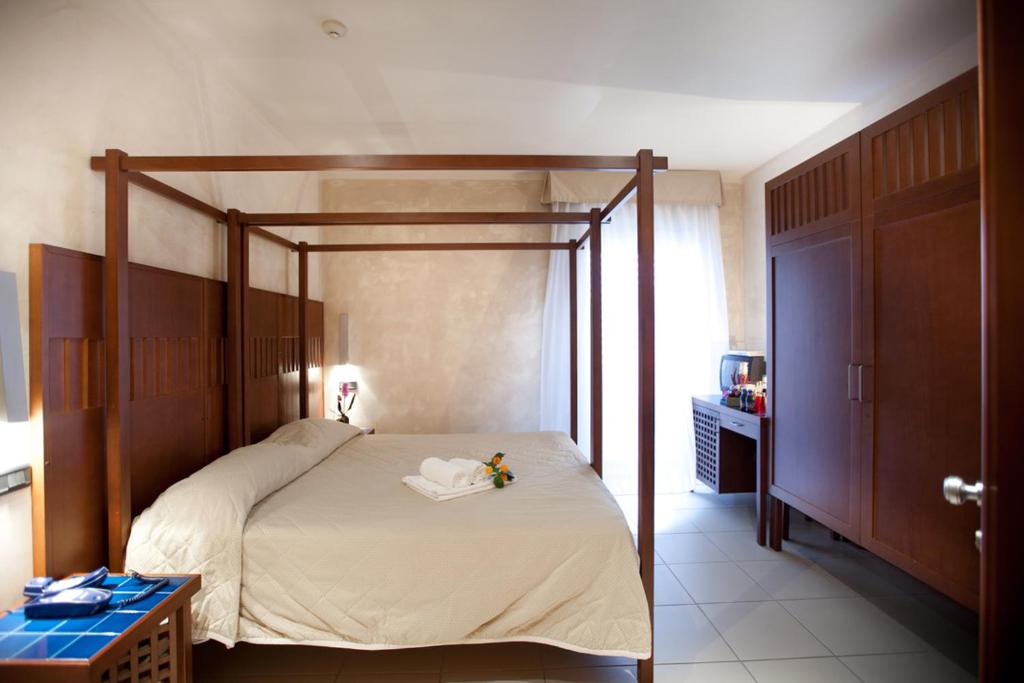 ein Schlafzimmer mit einem Himmelbett in einem Zimmer in der Unterkunft Hotel Canguro in San Benedetto del Tronto