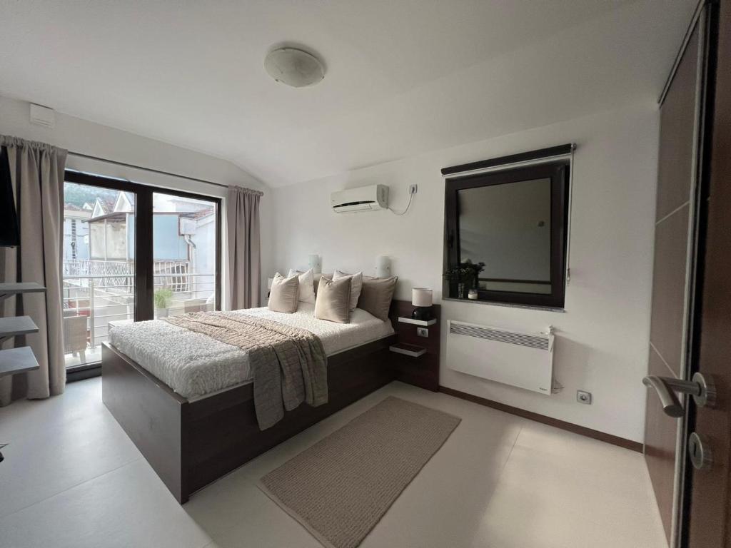 a bedroom with a bed with a mirror and a window at Apartments Villa Stefan in Budva