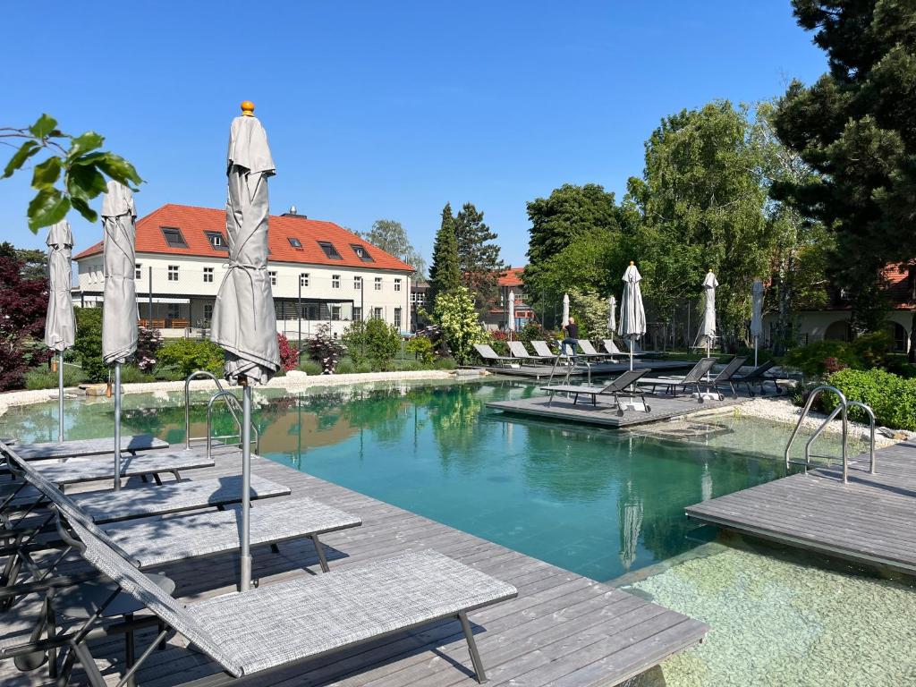 a swimming pool with lounge chairs and umbrellas at Hotel Spitzerberg by b-smart 