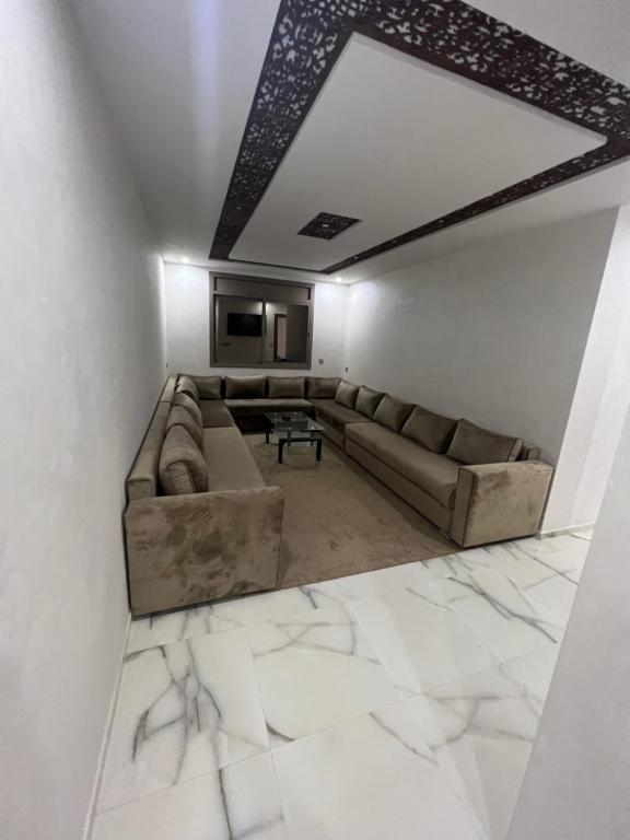 ein Wohnzimmer mit einem Sofa und einem Tisch in der Unterkunft Apartment Nador Jadid Hay Al Matar Appart 009 in Nador