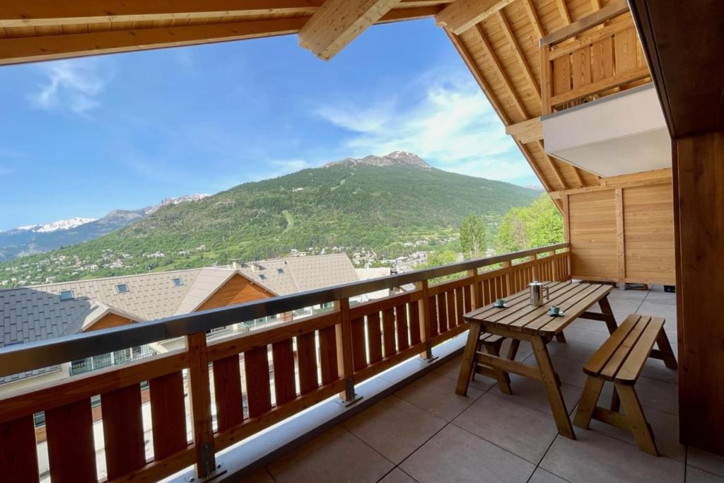 a balcony with a table and a view of a mountain at 100 m near the Cité Vauban in Briançon in Briançon