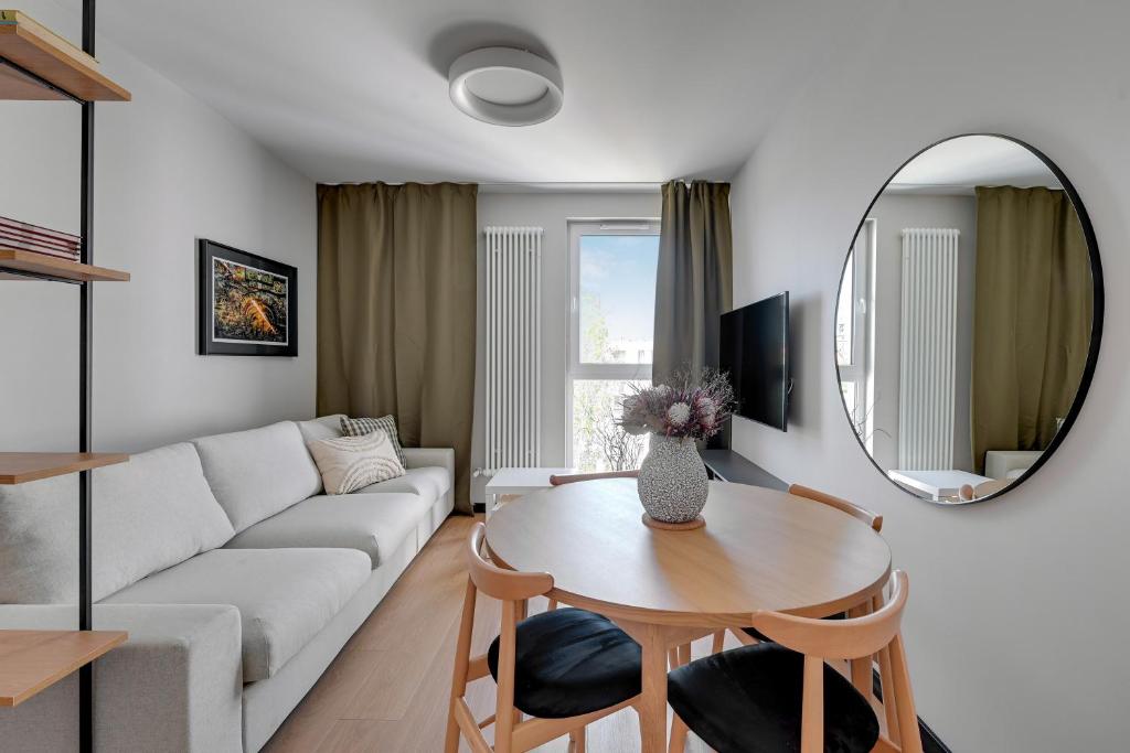 ein Wohnzimmer mit einem Sofa, einem Tisch und einem Spiegel in der Unterkunft Luxury Aura 40 - 6 by Grand Apartments in Danzig